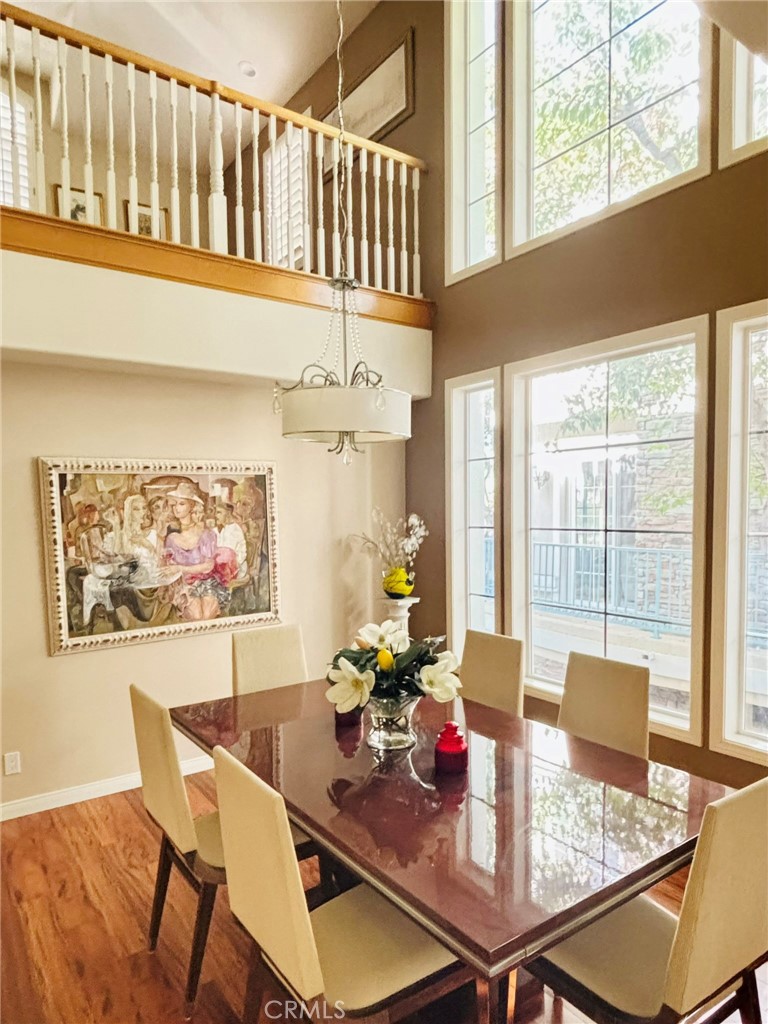 a view of a dining room with furniture a chandelier and wooden floor