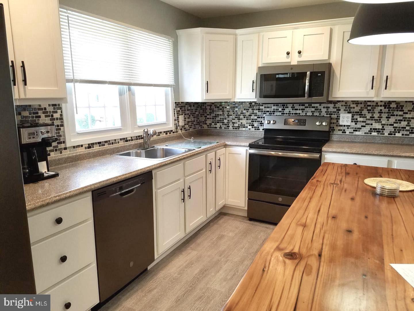 a kitchen with stainless steel appliances a stove sink microwave and cabinets