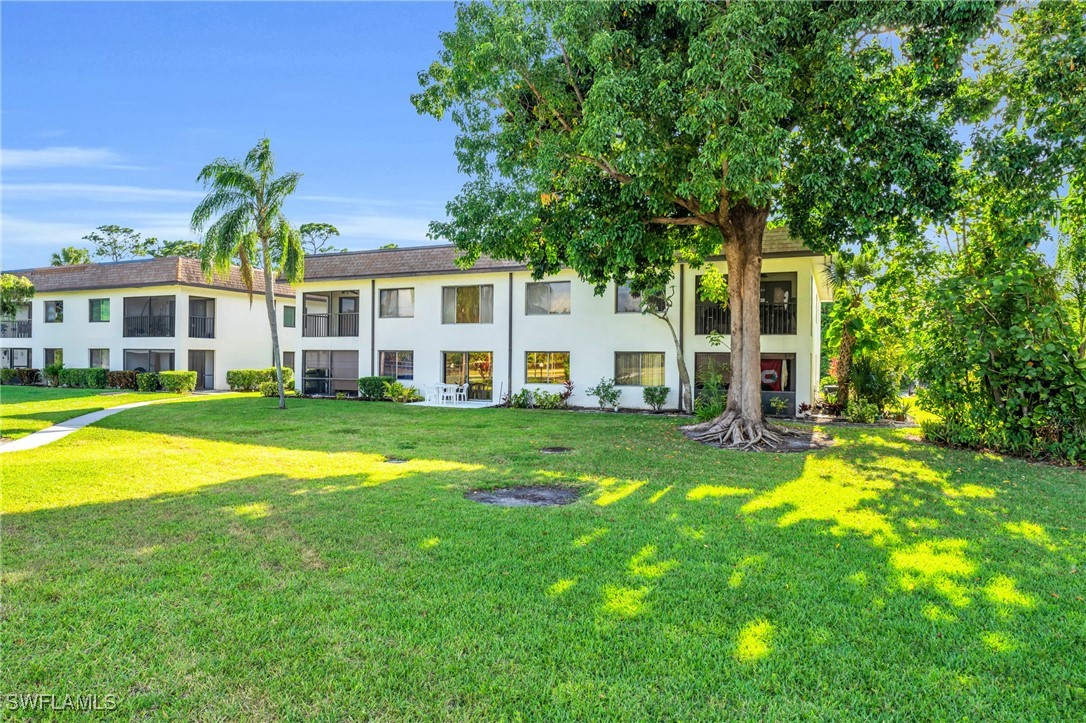 a view of a house with a big yard and large trees