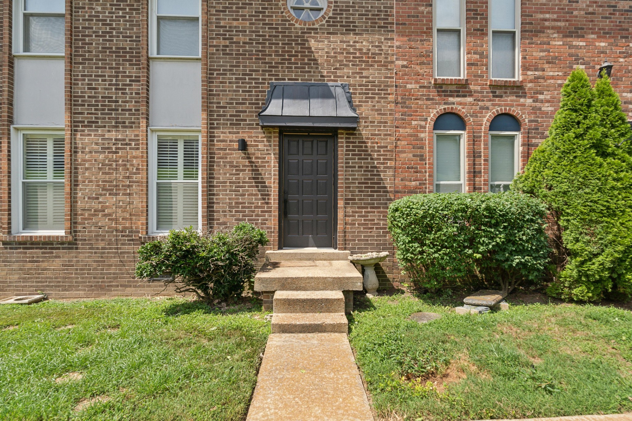 front view of a brick house with a yard