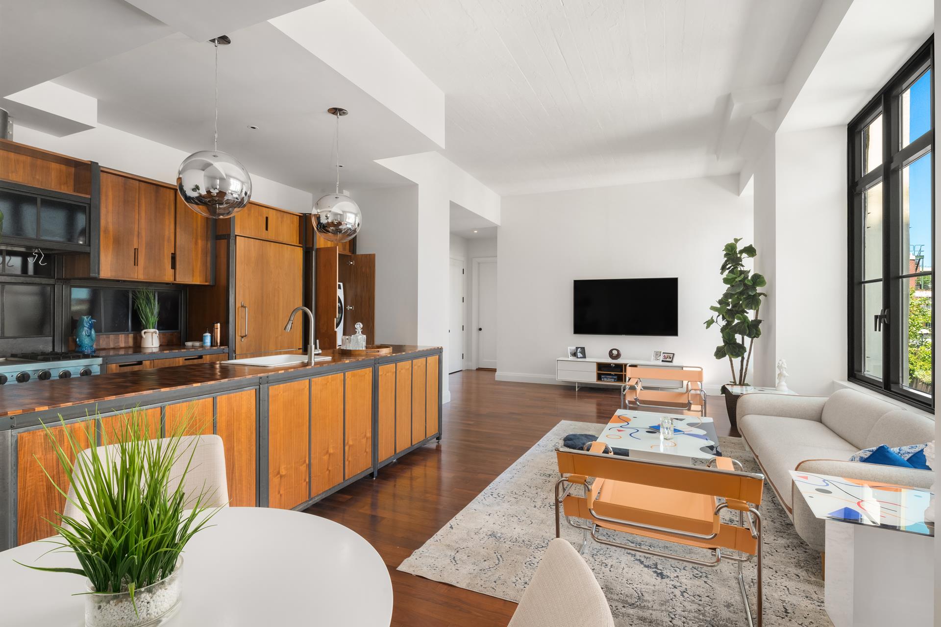 a living room with furniture a flat screen tv and a large window