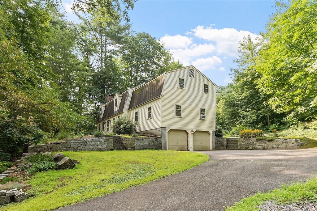 a view of a white house with a big yard and large trees