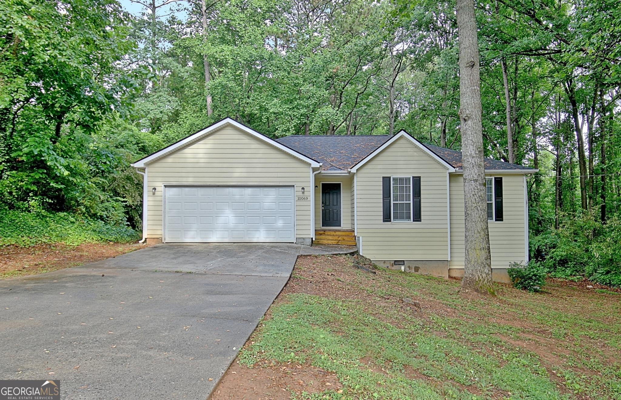 a front view of a house with a garden and yard