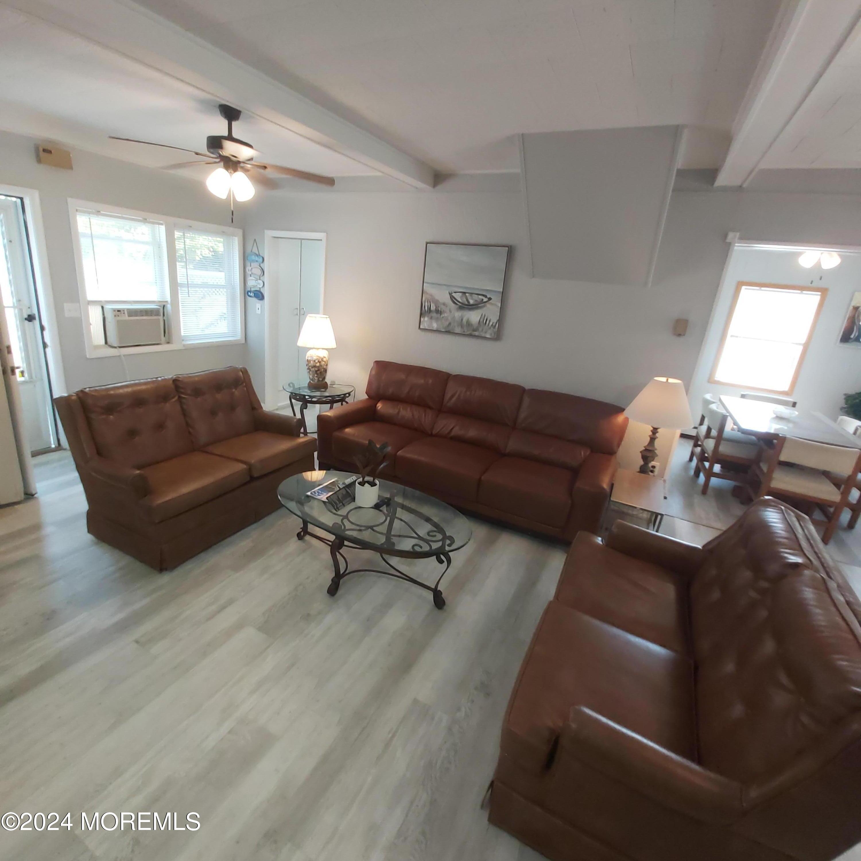 a living room with furniture and a large mirror next to a window