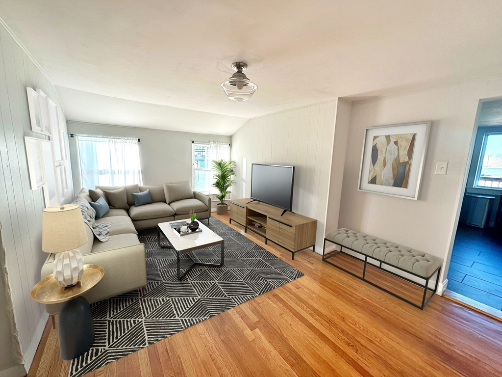 a living room with furniture and a wooden floor