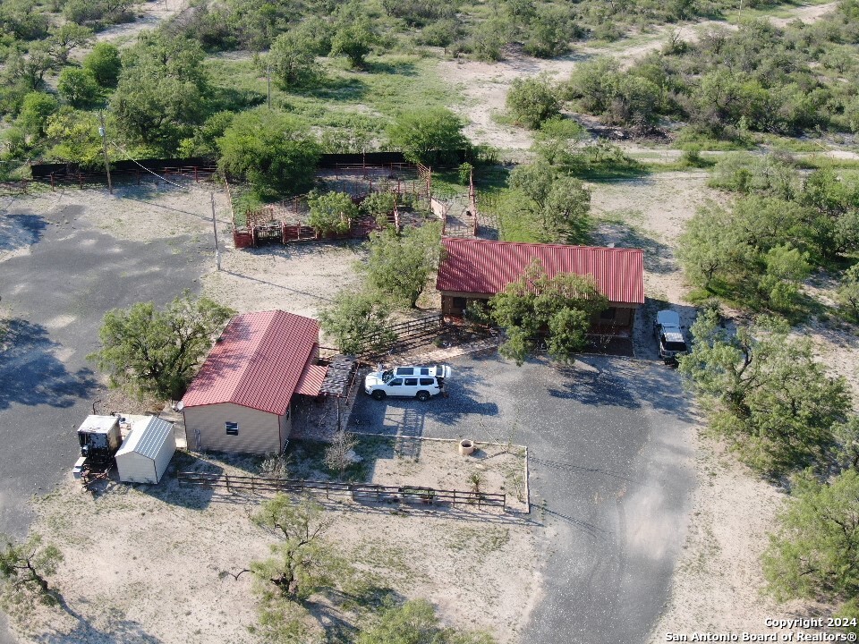 an aerial view of a house with a yard and greenery