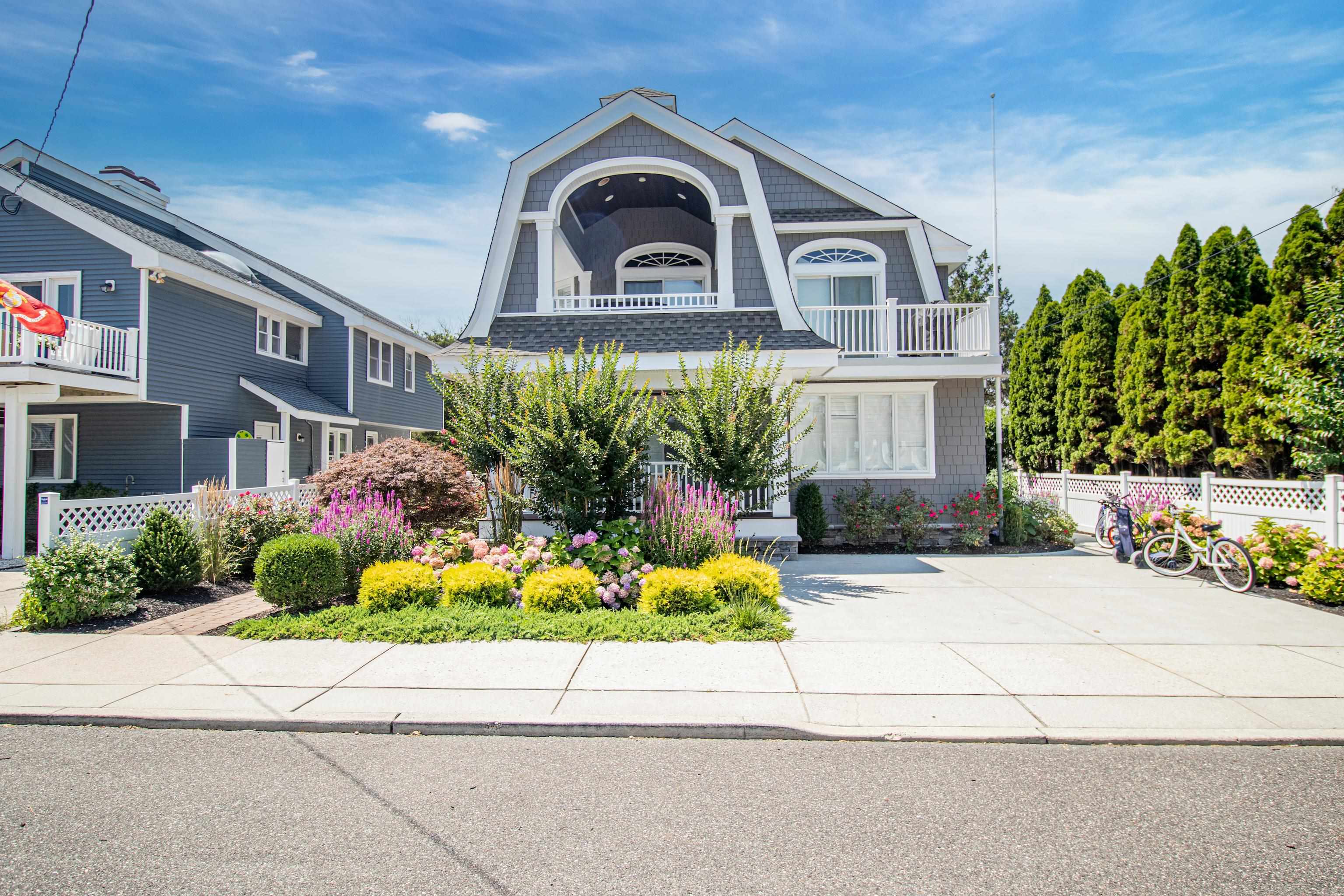 a front view of a house with a yard and potted plants