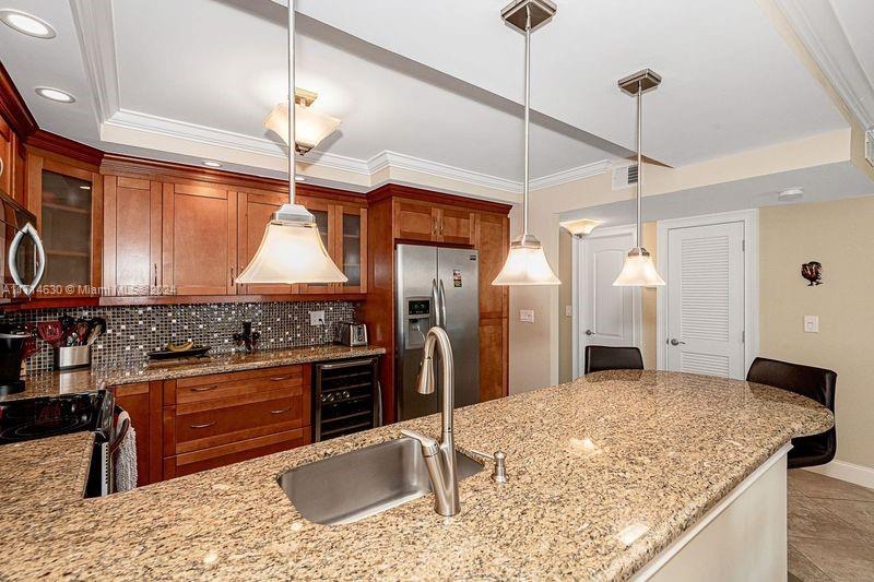 a kitchen with stainless steel appliances granite countertop a sink a stove and a refrigerator