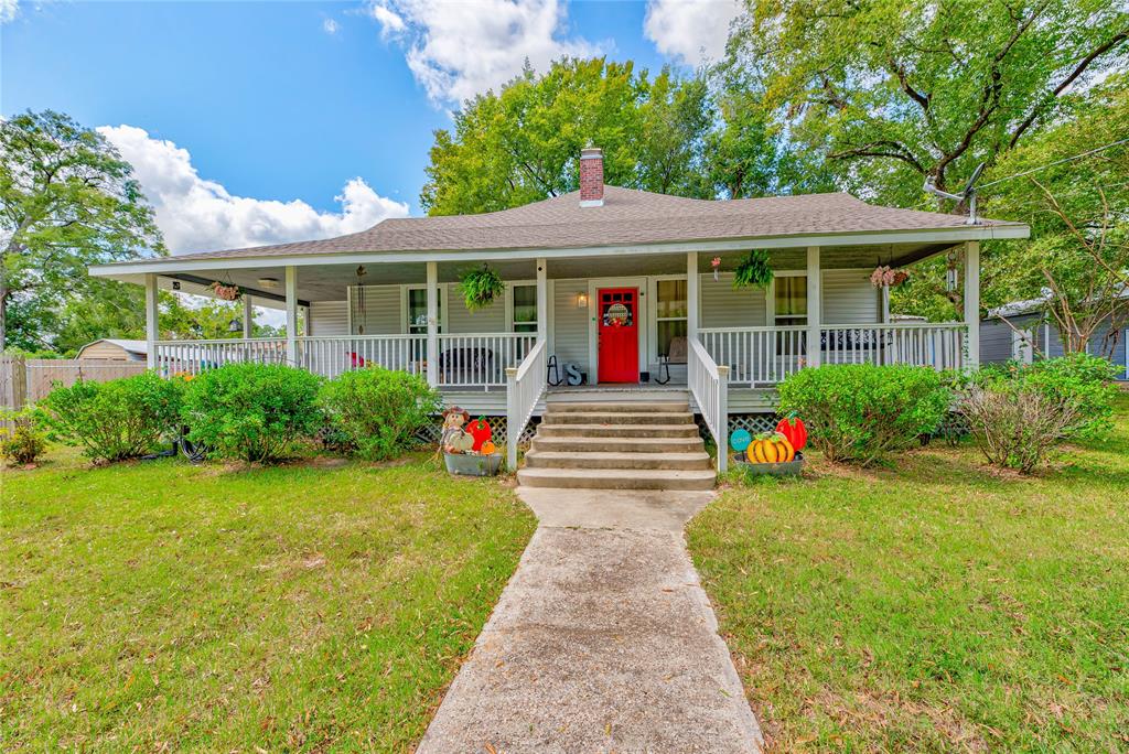 a front view of a house with a yard garden and outdoor seating