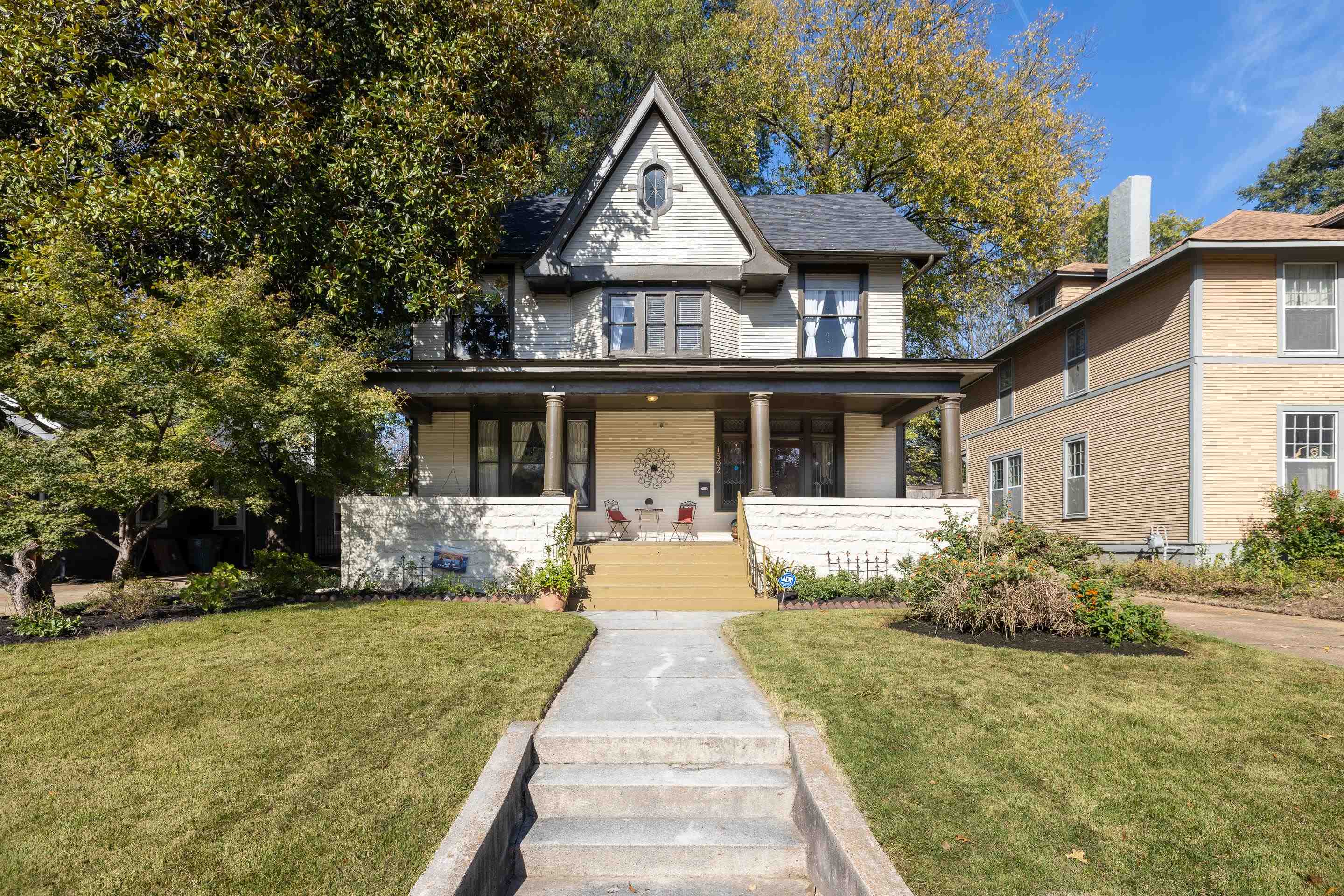 a front view of a house with yard and green space