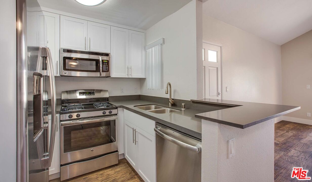 a kitchen with stainless steel appliances granite countertop a sink stove and microwave