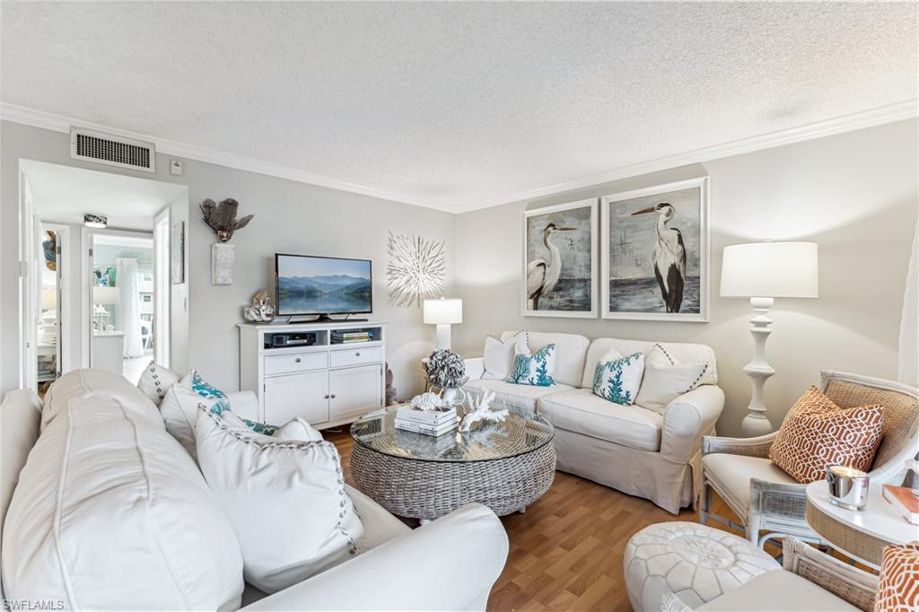 a living room with furniture and a view of kitchen