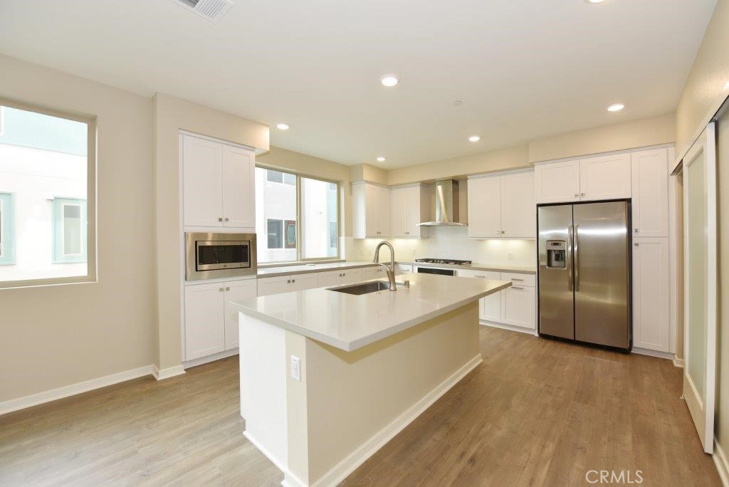 a large kitchen with kitchen island a sink stainless steel appliances and cabinets