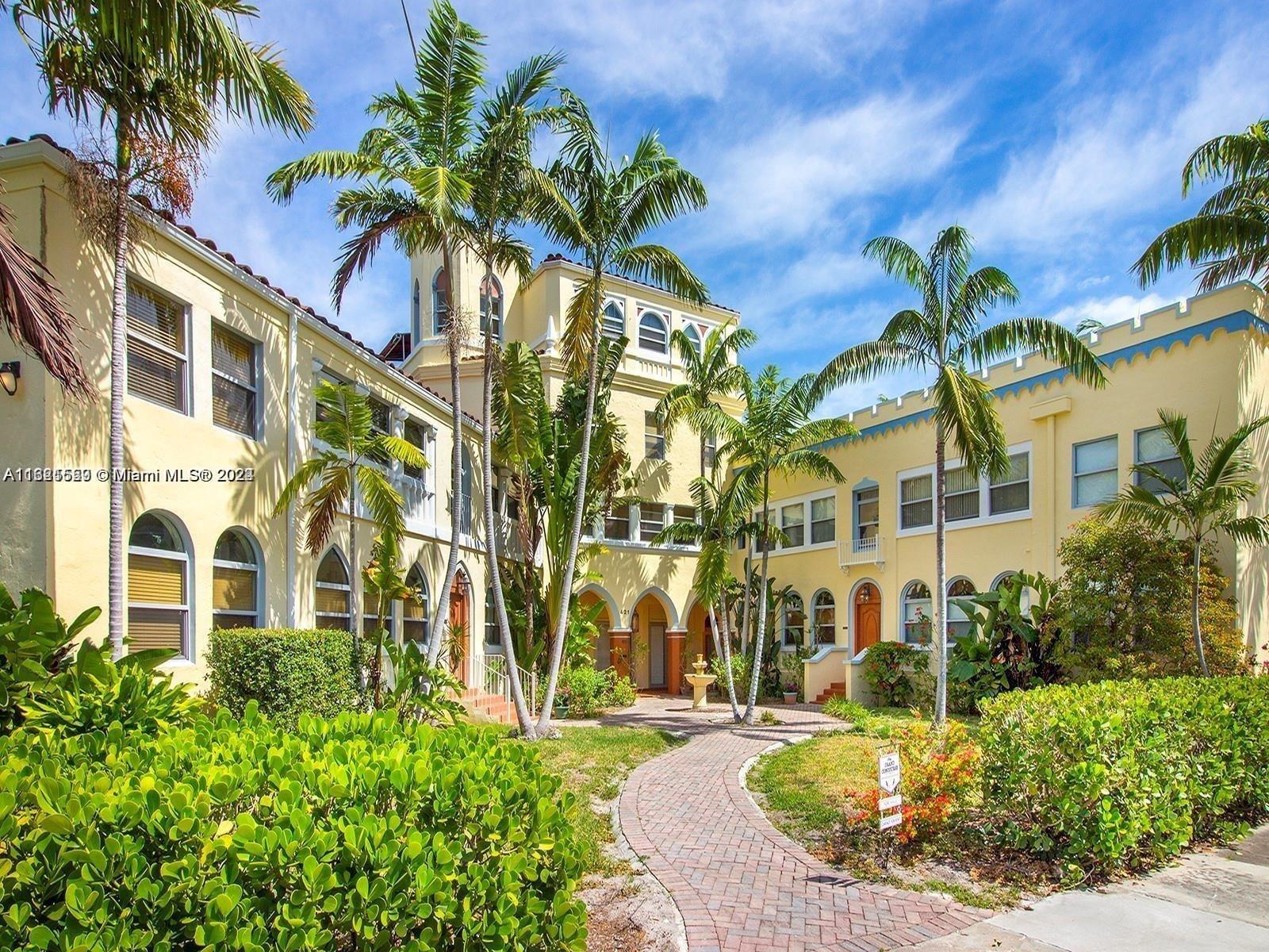 a view of a multi story residential apartment building with a yard and balcony