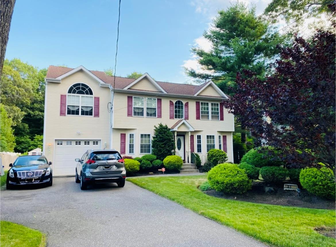 View of front facade with a front lawn and a garage