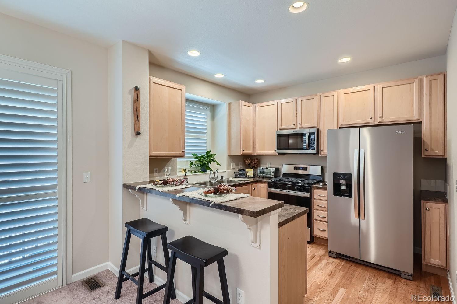 a kitchen with a refrigerator a stove a sink and white cabinets