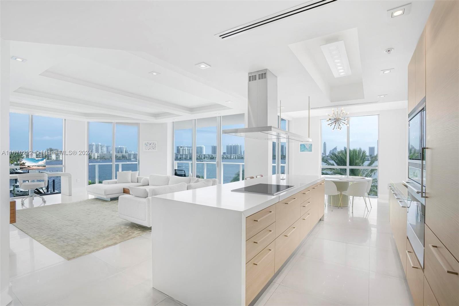 a large white kitchen with a large window and stainless steel appliances