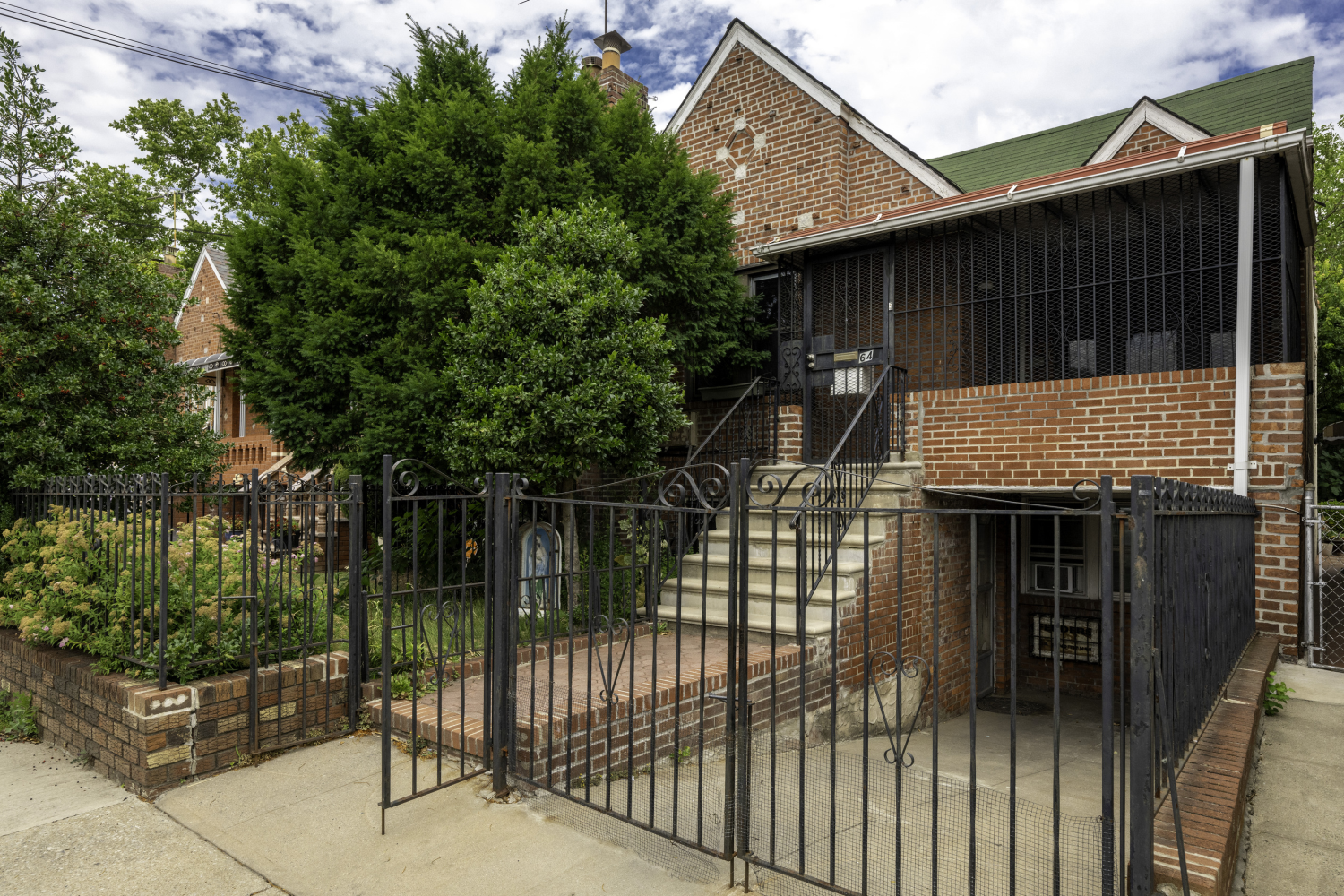 a view of house with a tree and wooden fence