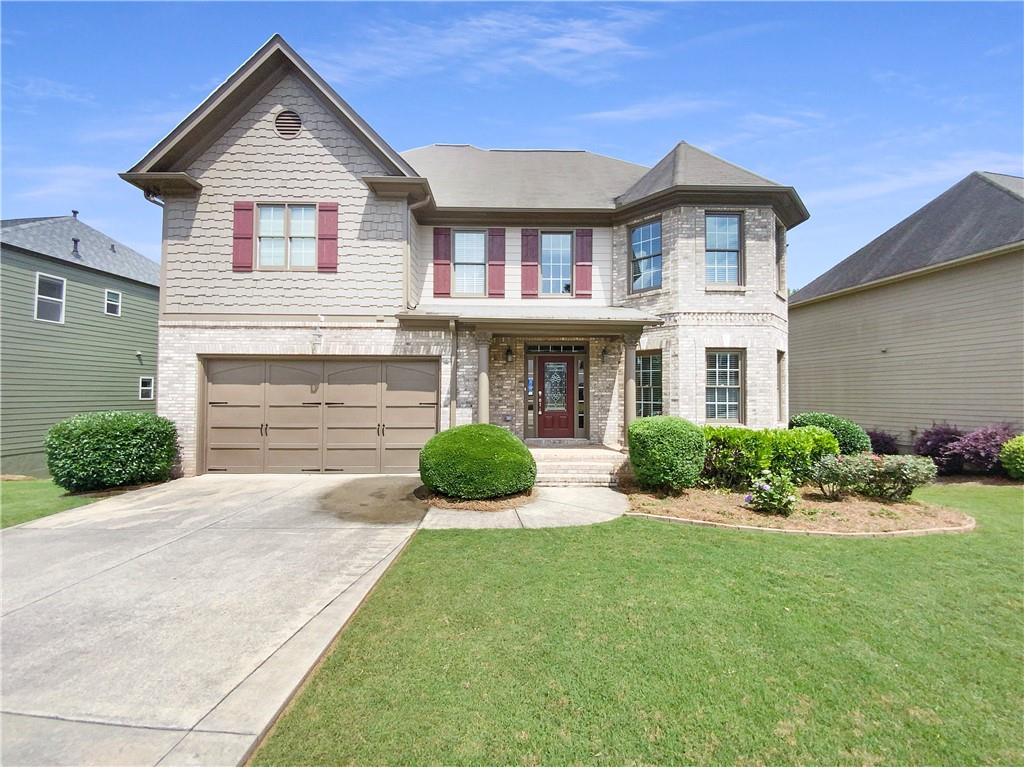 a front view of a house with a yard and garage