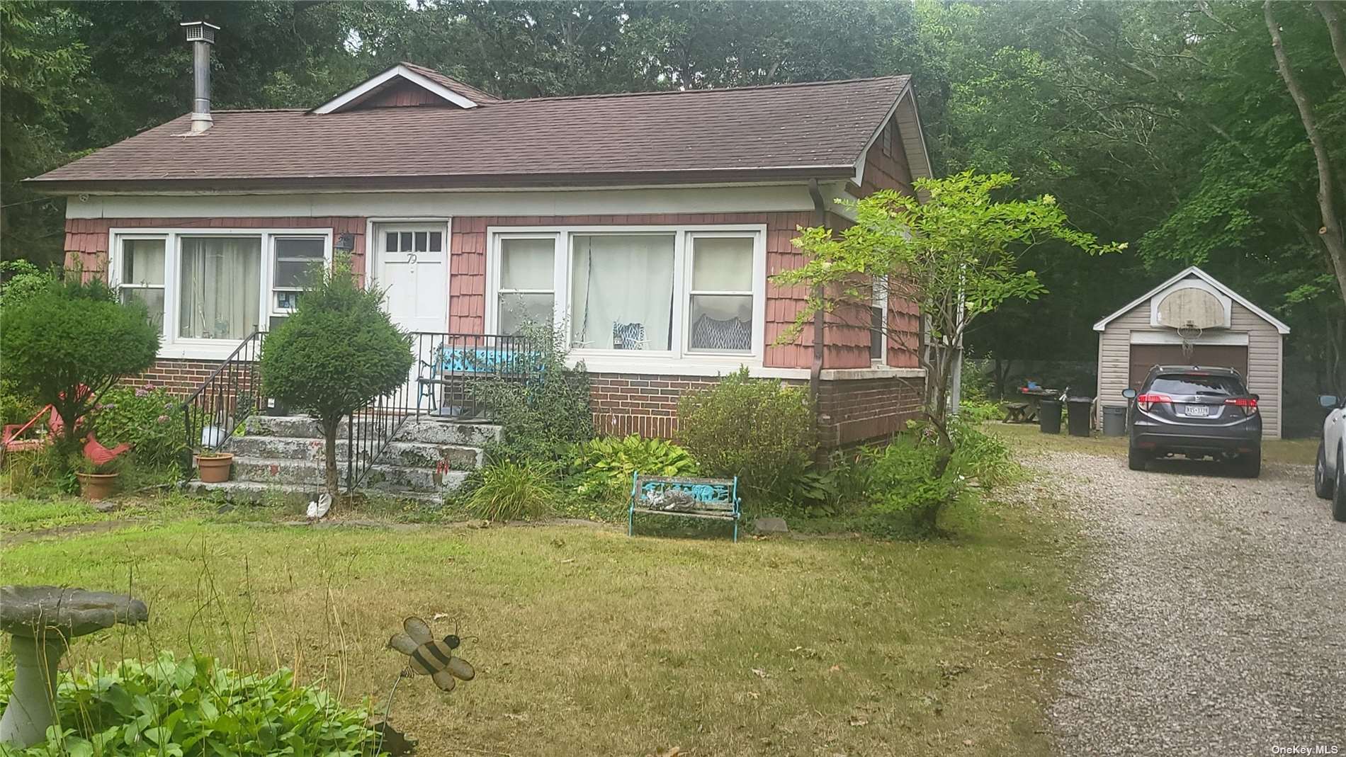 a front view of a house with a yard and potted plants