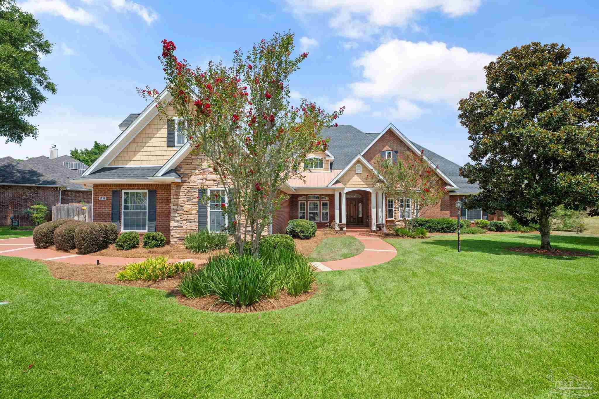 a front view of a house with yard and green space