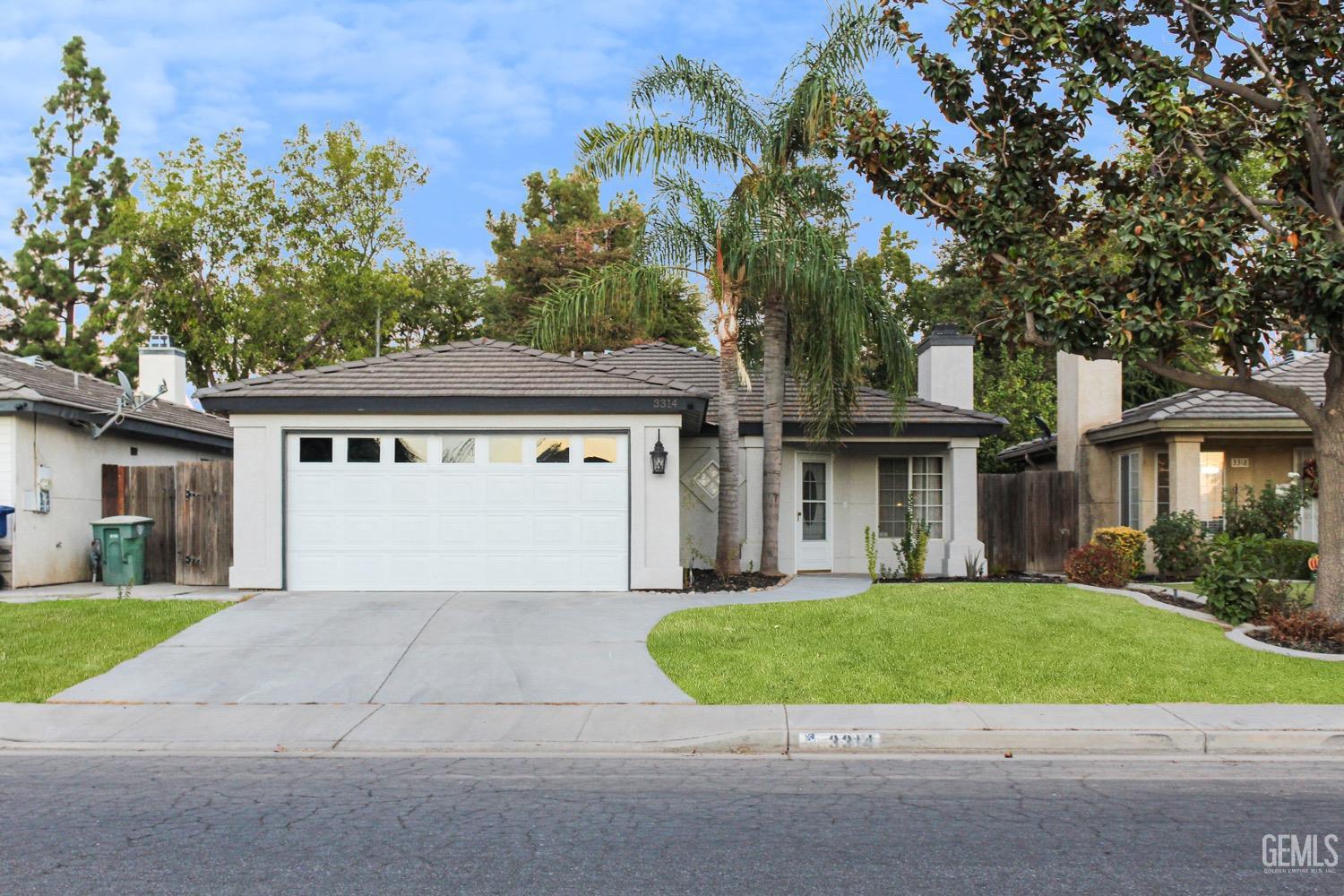 a front view of a house with a yard and potted plants