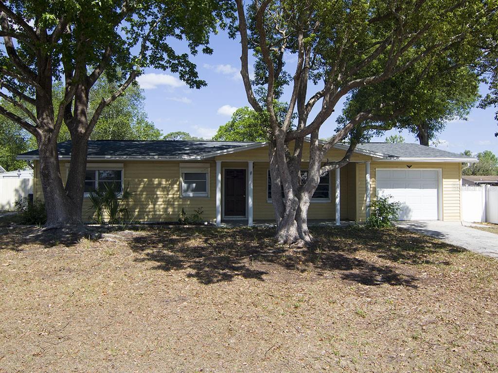 a front view of a house with a tree