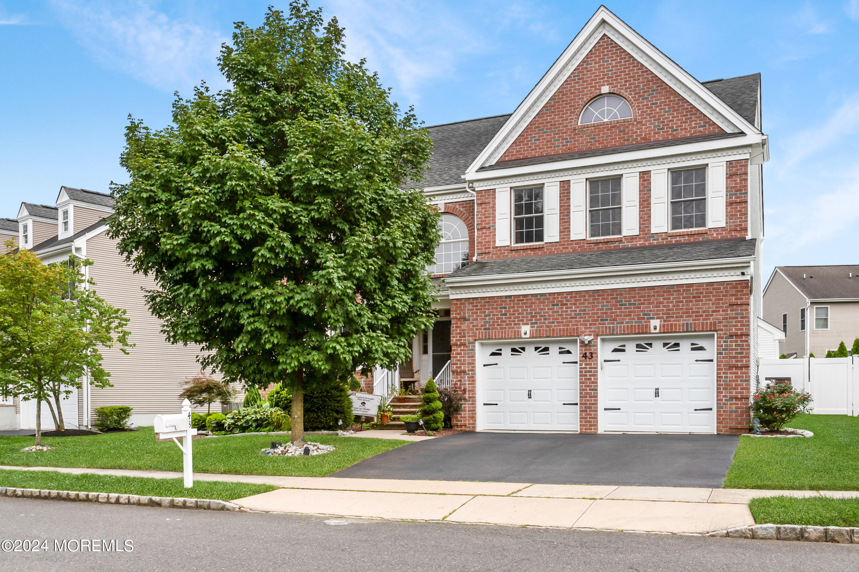 a front view of a house with a garden and garage