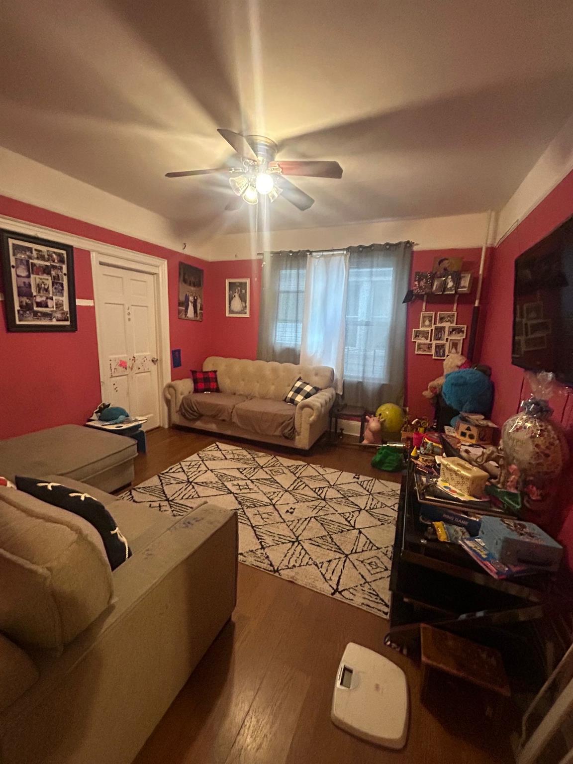 Living room with ceiling fan and hardwood / wood-style flooring