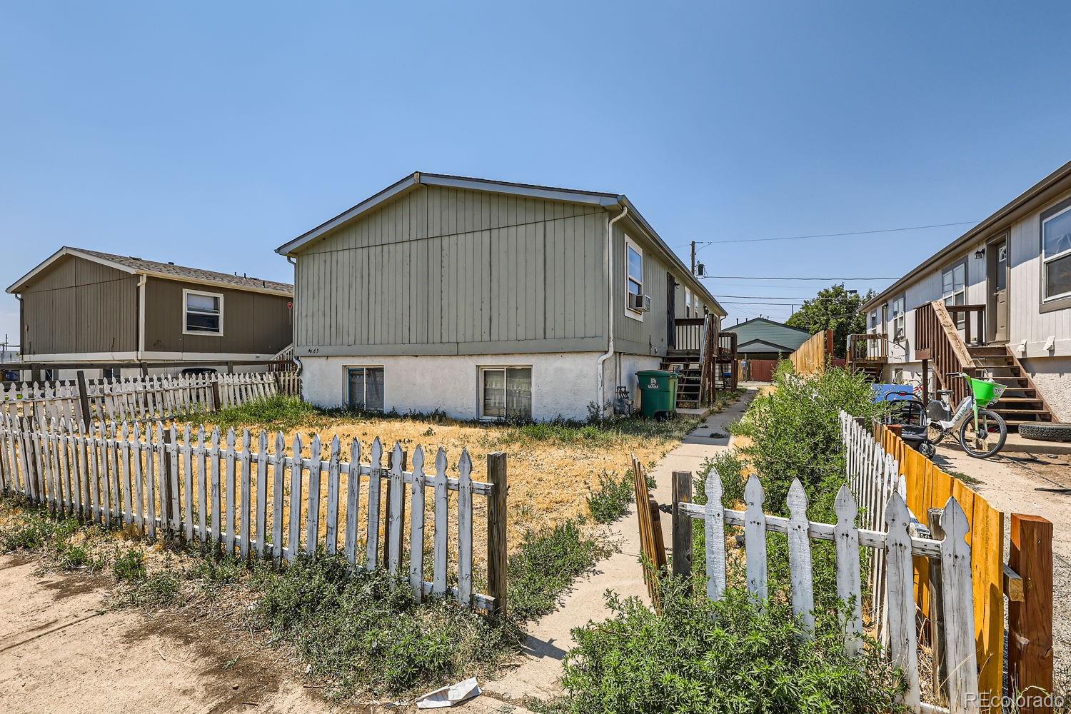 a view of a house with wooden fence