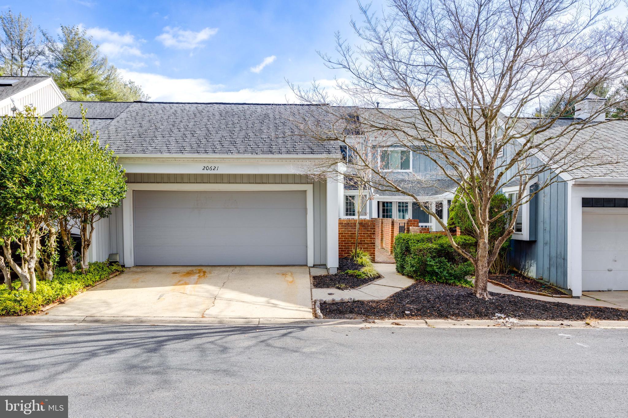 a front view of a house with a yard and a garage