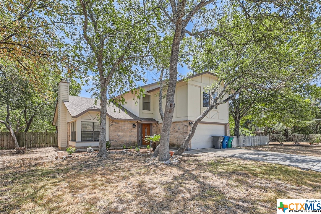 a view of a house with a yard and tree