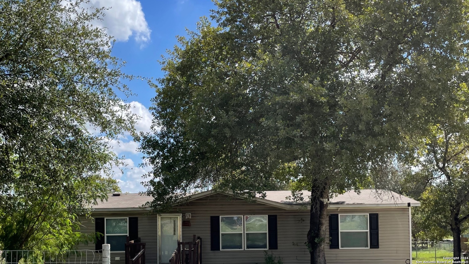 a front view of a house with a tree