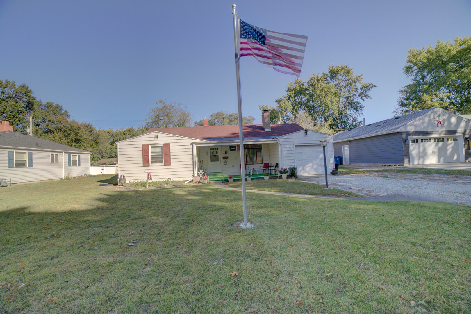 a front view of a house with a yard and trees