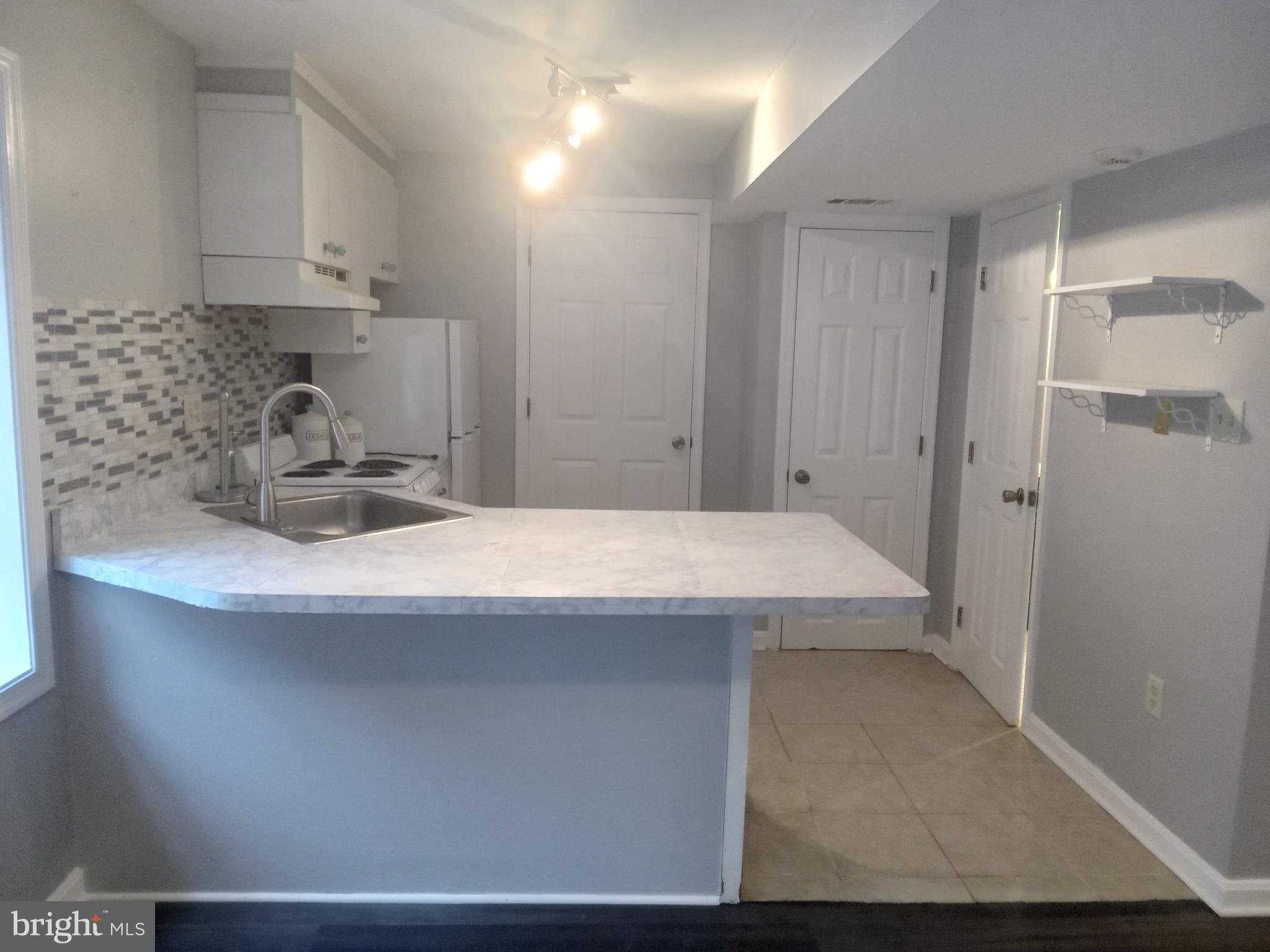 a kitchen with kitchen island a sink a stove and refrigerator