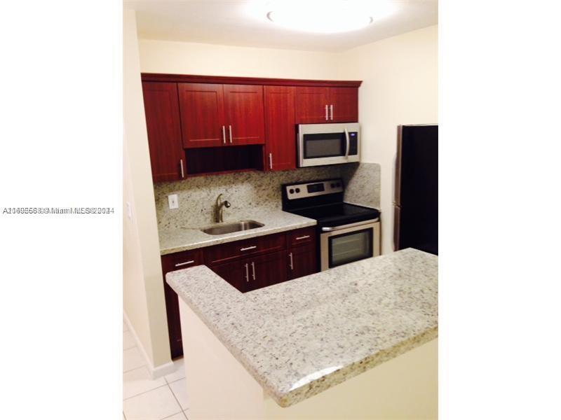 a kitchen with stainless steel appliances a microwave a stove and refrigerator