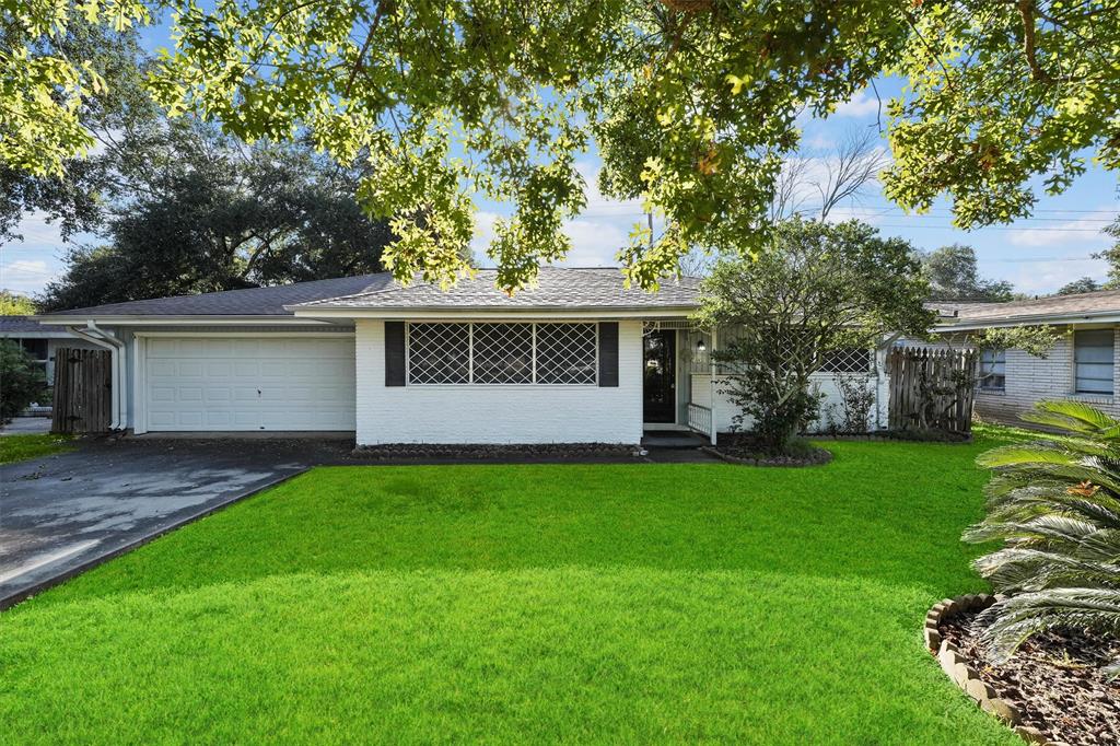 a view of a house with a yard and tree