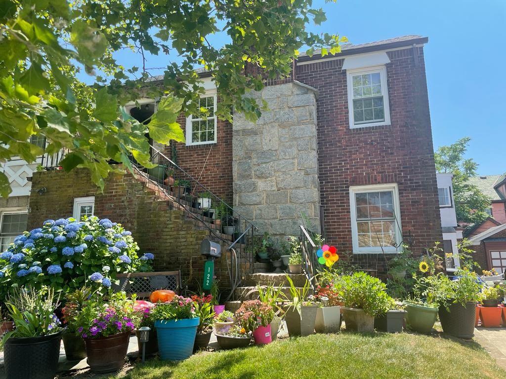 a front view of a house with a yard and a garden