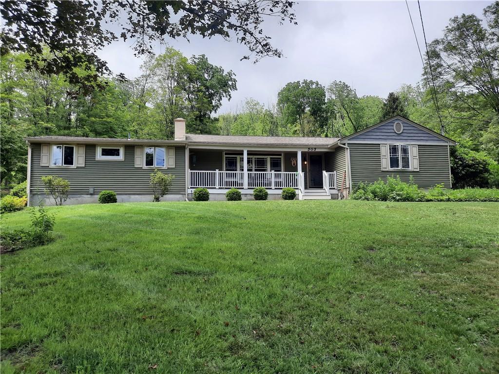 a view of a house with a yard and sitting area