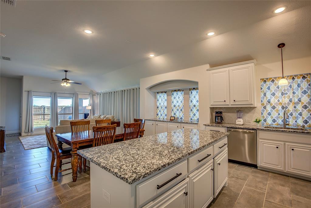 a kitchen with center island table and chairs