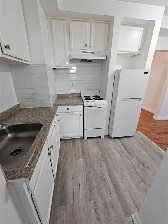 a kitchen with a sink a stove and cabinets