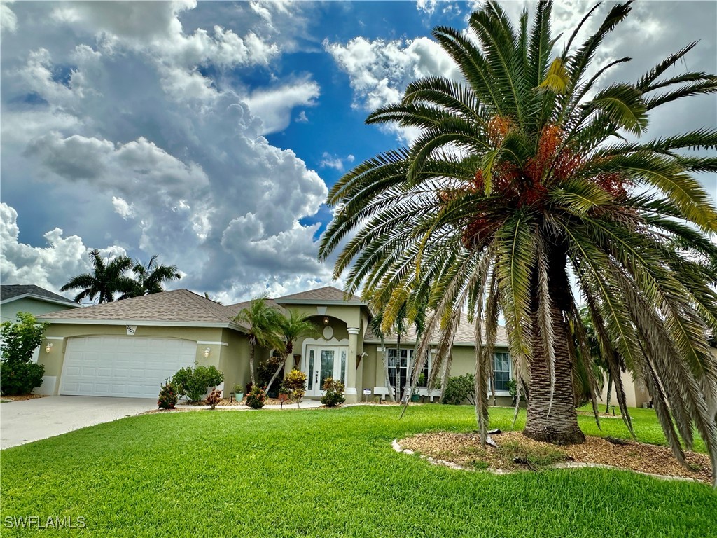 a view of a white house with a big yard and a palm tree