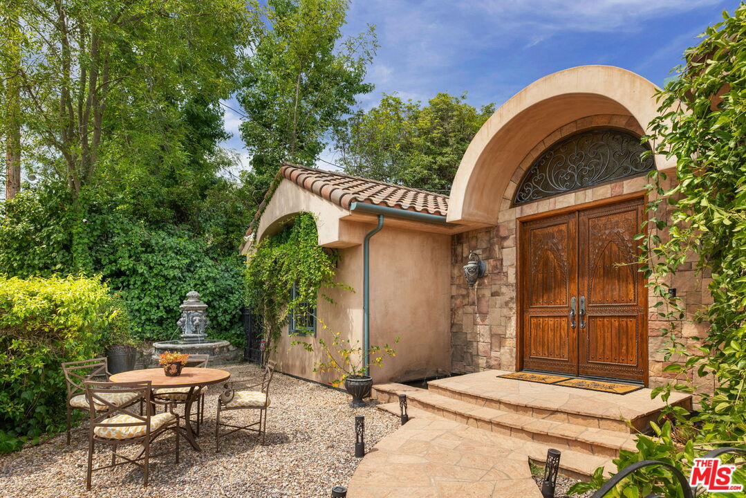 a backyard of a house with table and chairs