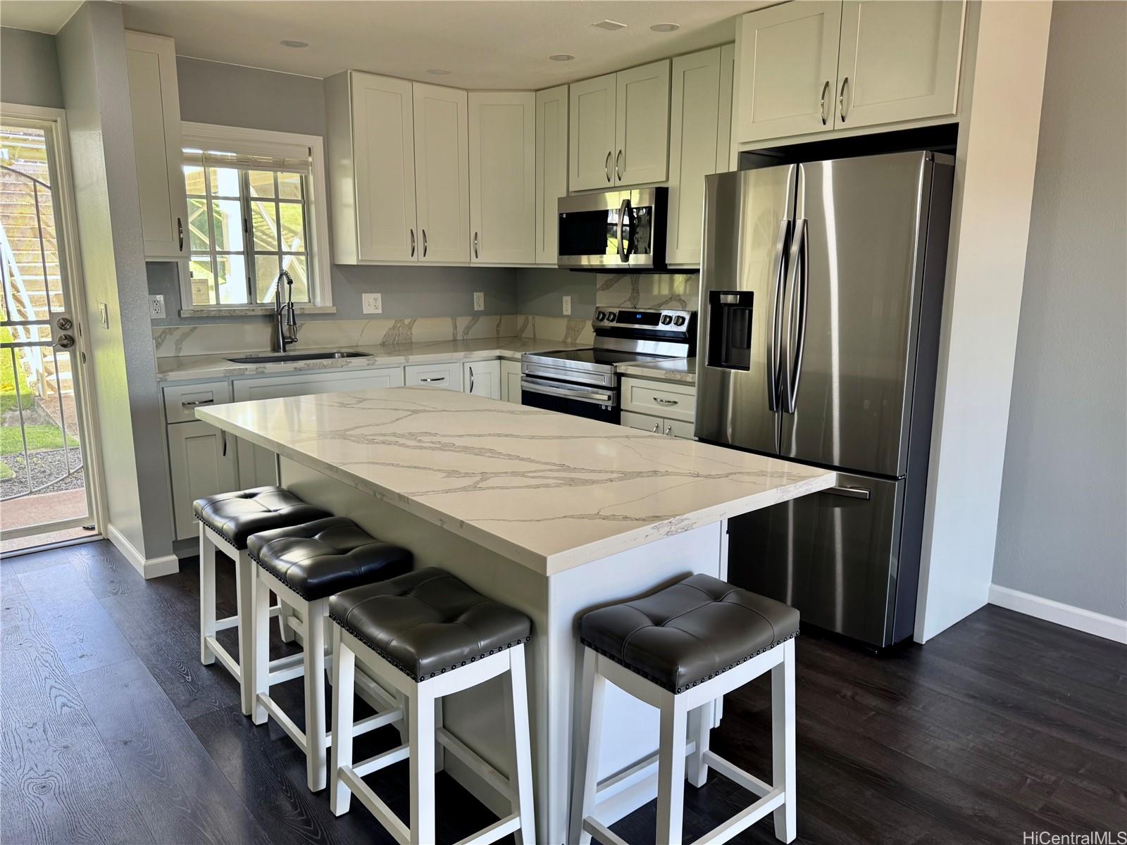 a kitchen with stainless steel appliances a table chairs and wooden floor