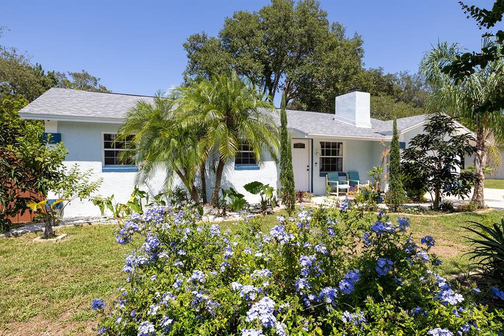 a front view of a house with a big yard and potted plants