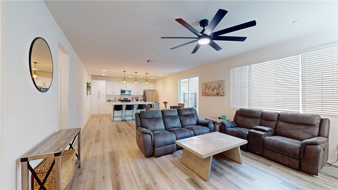 a living room with furniture a rug potted plant and a window