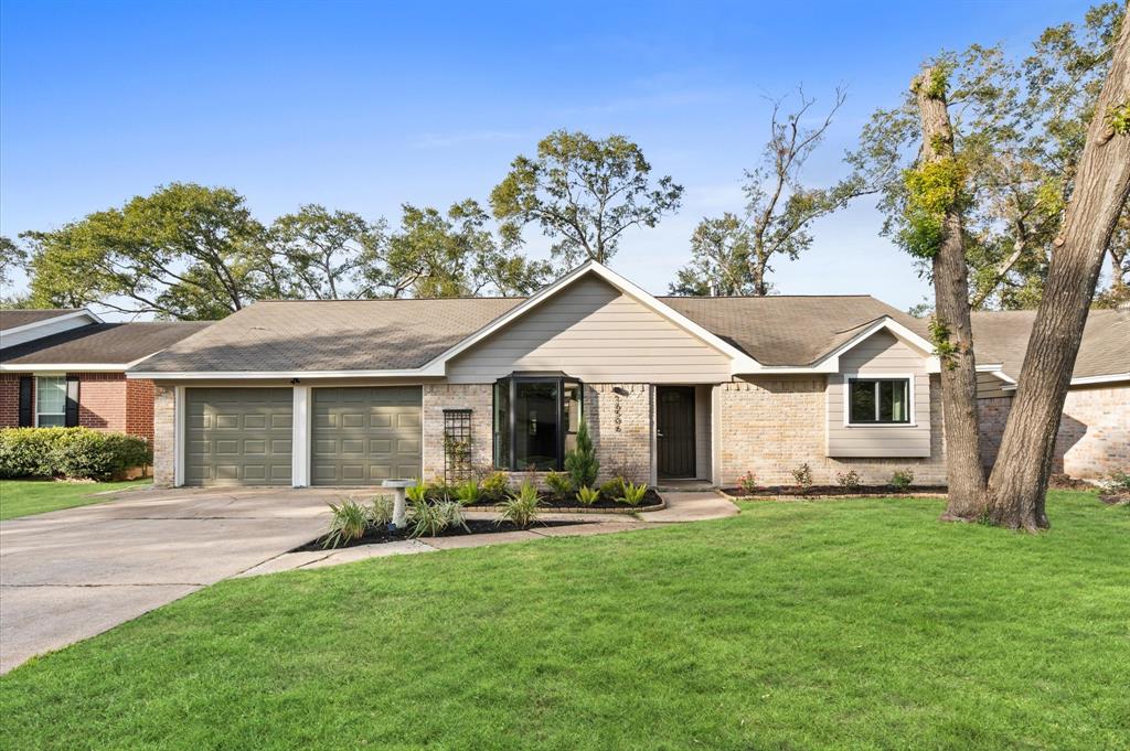 a front view of a house with a yard and trees