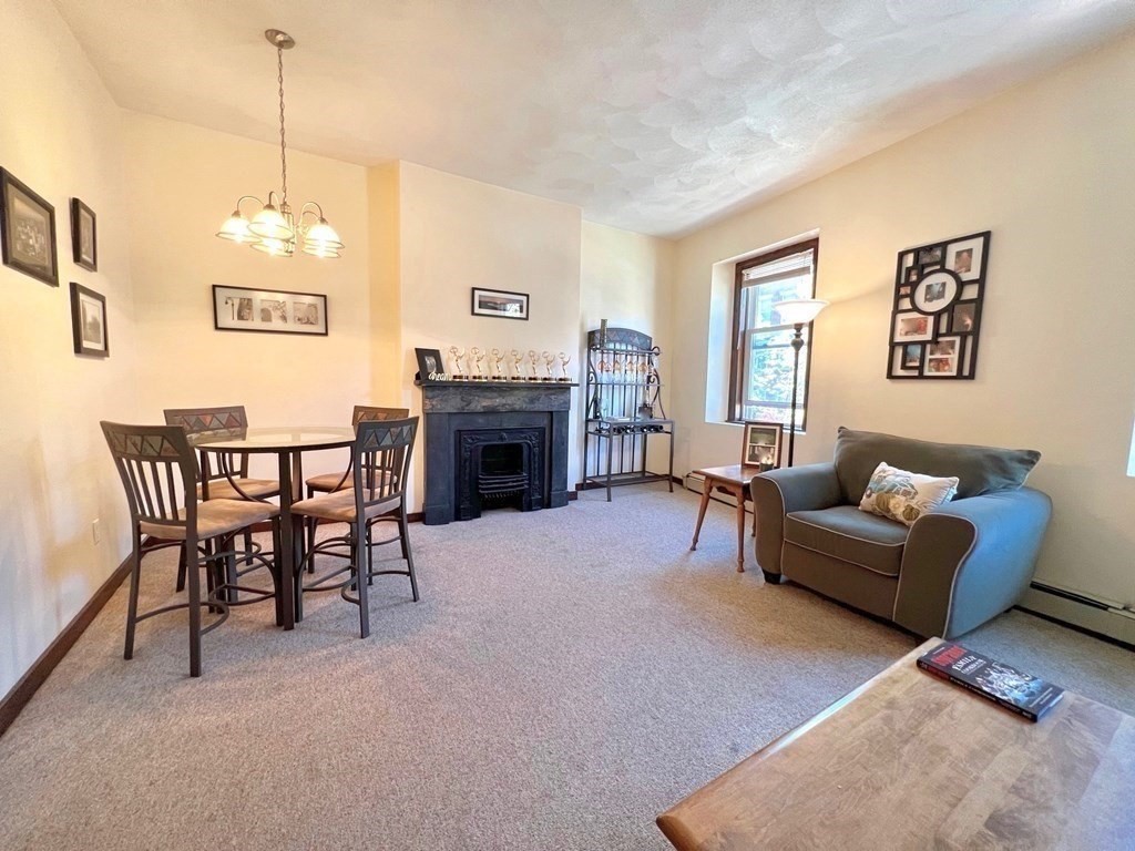 a living room with furniture a dining table and a fireplace