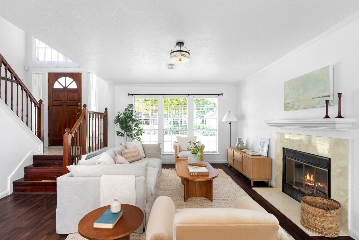 a living room with furniture a fireplace and a large window