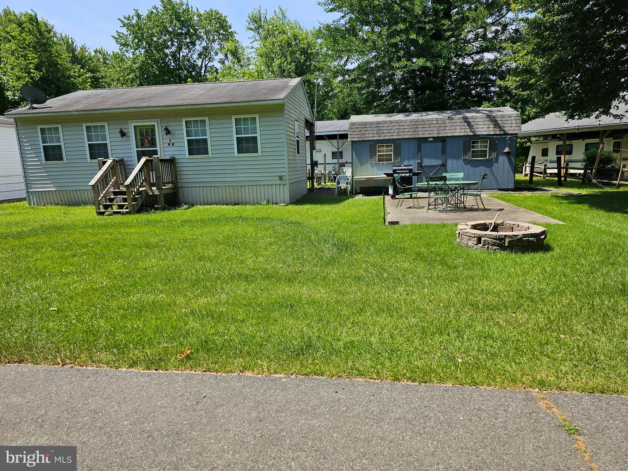 a view of a yard with a table and chairs under an umbrella